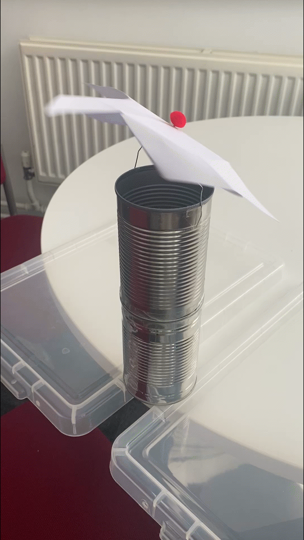 Moving gif of the solar updraft tower of two tins cans and a paper windmill spinning