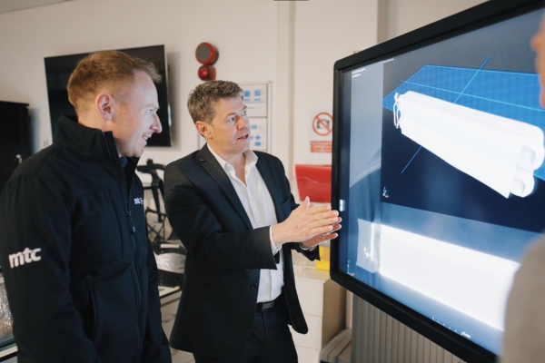 Two engineers looking at a 3d render on a screen