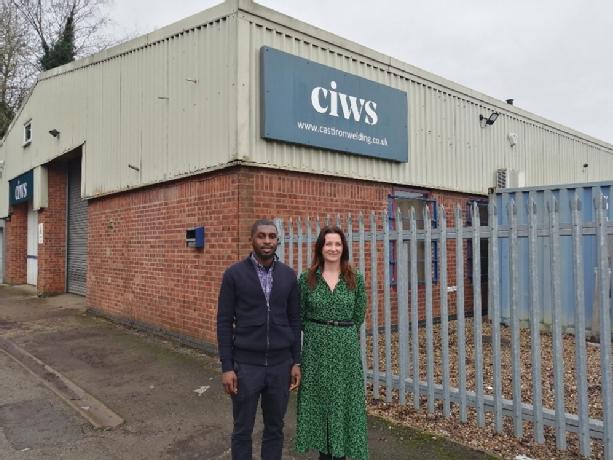 Two colleagues standing outside the front of the CIWS factory.