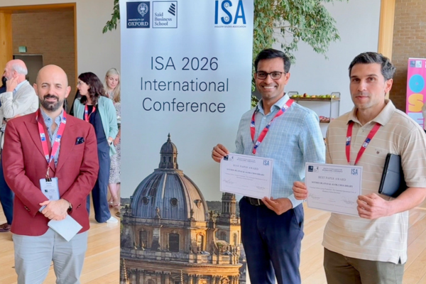 WMG researchers hold "Best Paper Award" certificates in front of an "ISA 2026 International Conference" banner