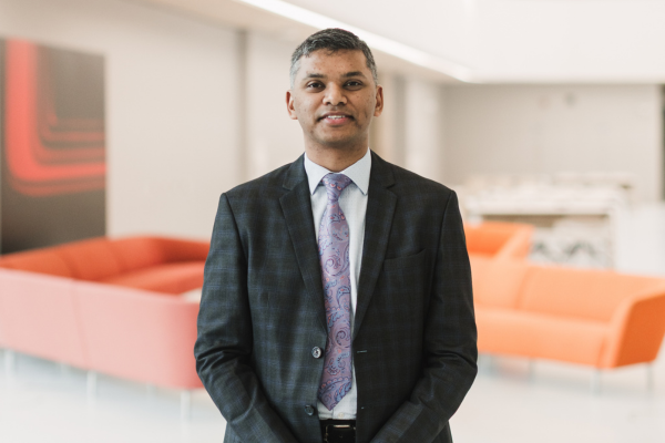 Man wearing a suit smiles to the camera
