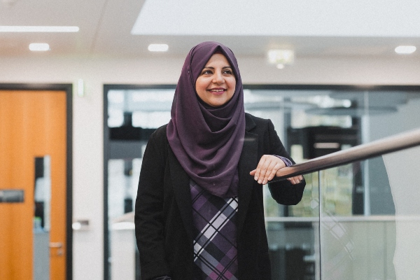 Freeha Azmat smiles while standing in a modern building at WMG