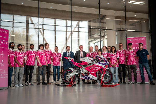 Warwick Moto team in pink WMG-branded shirts with pink electric motorbike, Panther.