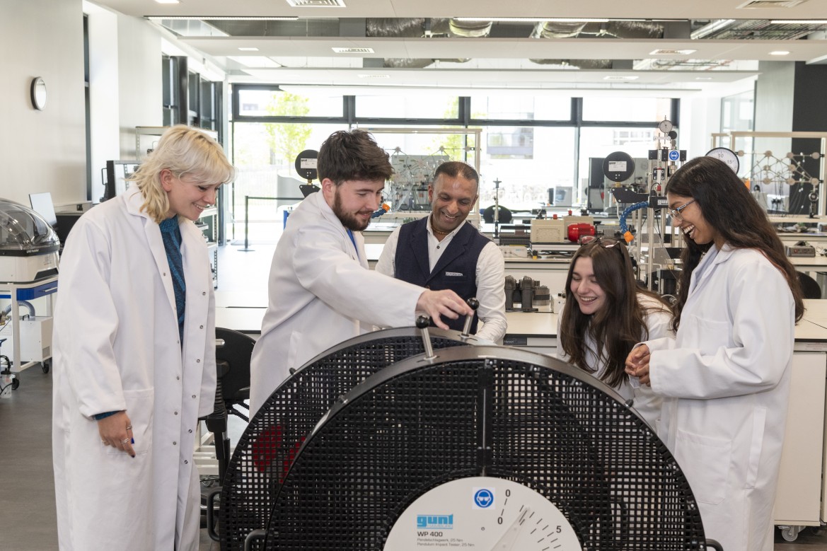 Degree Apprentices and a tutor interacting with equipment in a lab