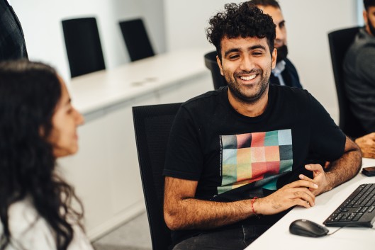 Degree Apprentices in a computer lab chatting to each other