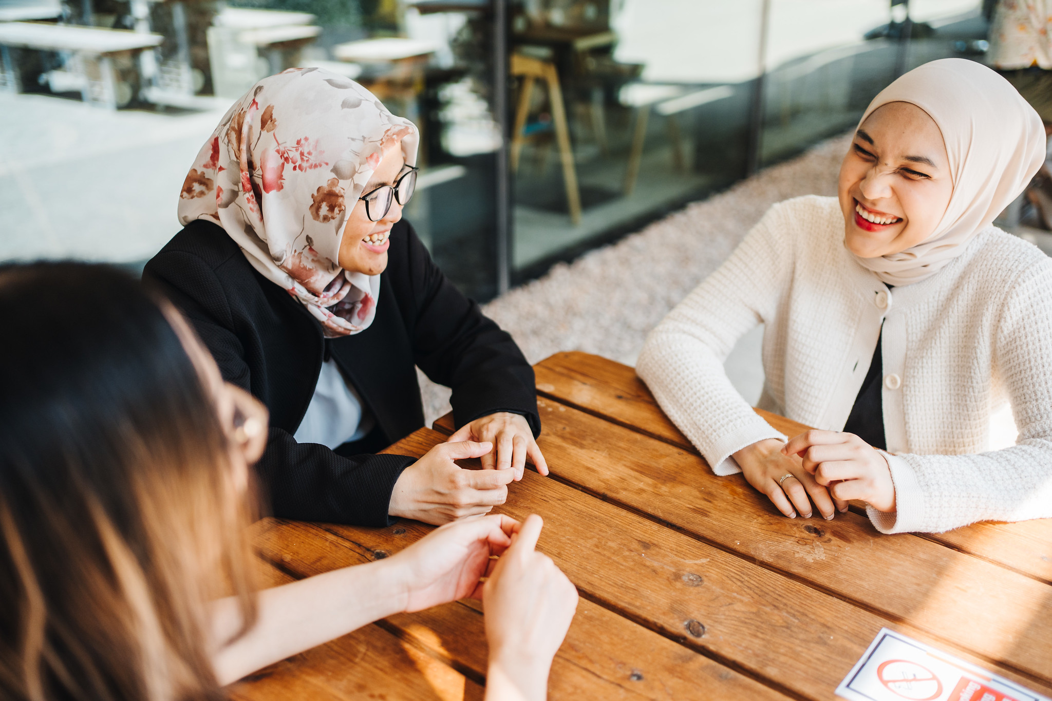 Two muslim female students in cafe