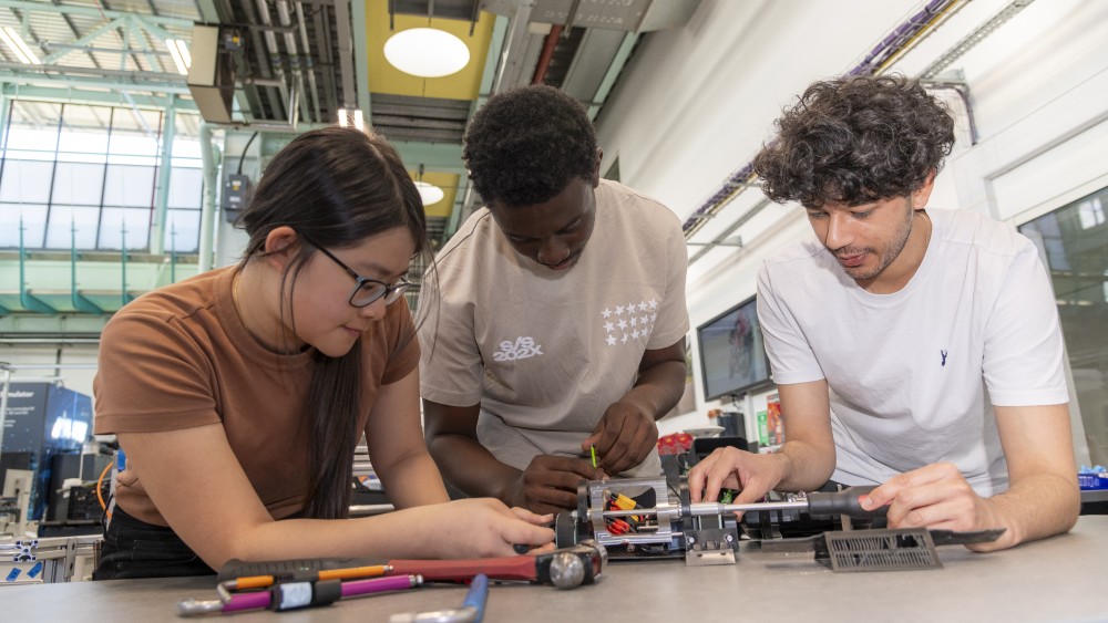 A group of students working on a miniature robot