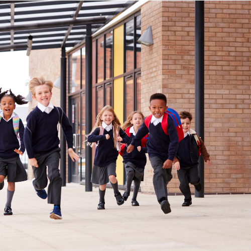 Group of young children running and smiling.