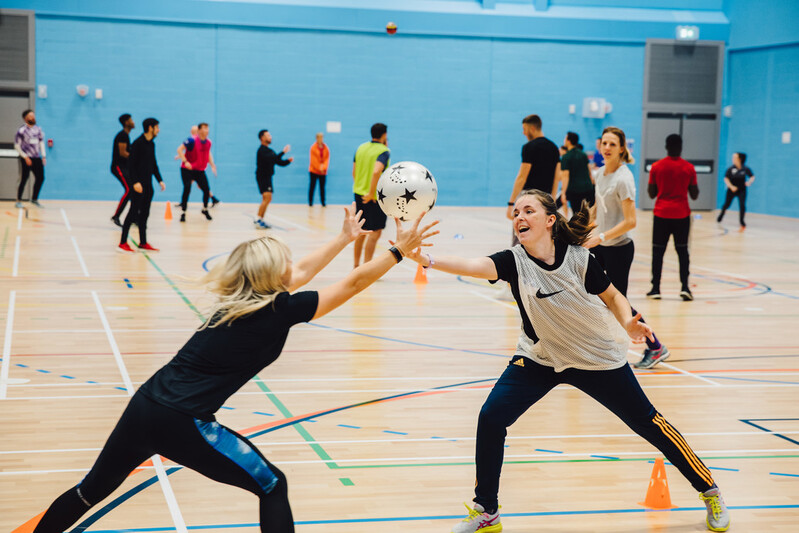 students jostle for control of a ball in a PE class