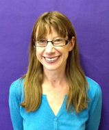 Corinna Grindle photo - woman with brown hair and glasses wearing a blue shirt