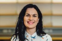 Jen Rowan-Lancaster photo - woman with black hair wearing a white top with birds on it