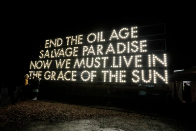 Image of lights in the dark saying end the oil age salvage paradise now we must live in the grace of the sun