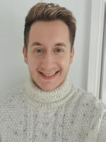 Adam Chapman photo - young man with brown hair wearing a white jumper smiling