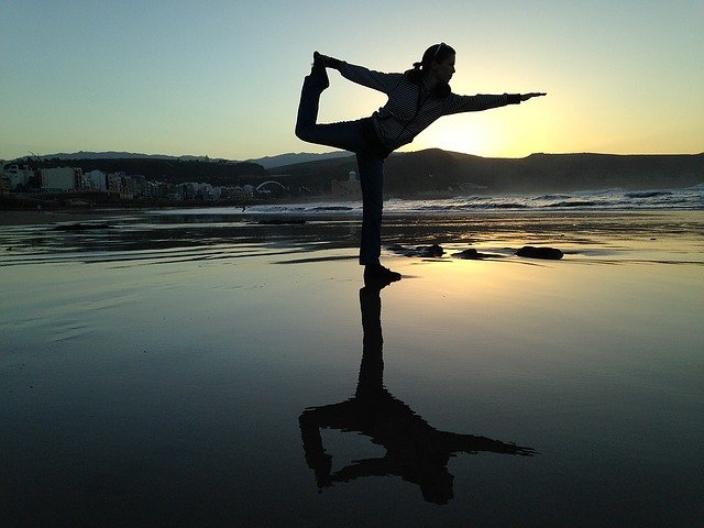 Person doing yoga on a beach