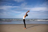 Person doing yoga on a beach