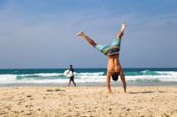 Person doing handstand on a beach