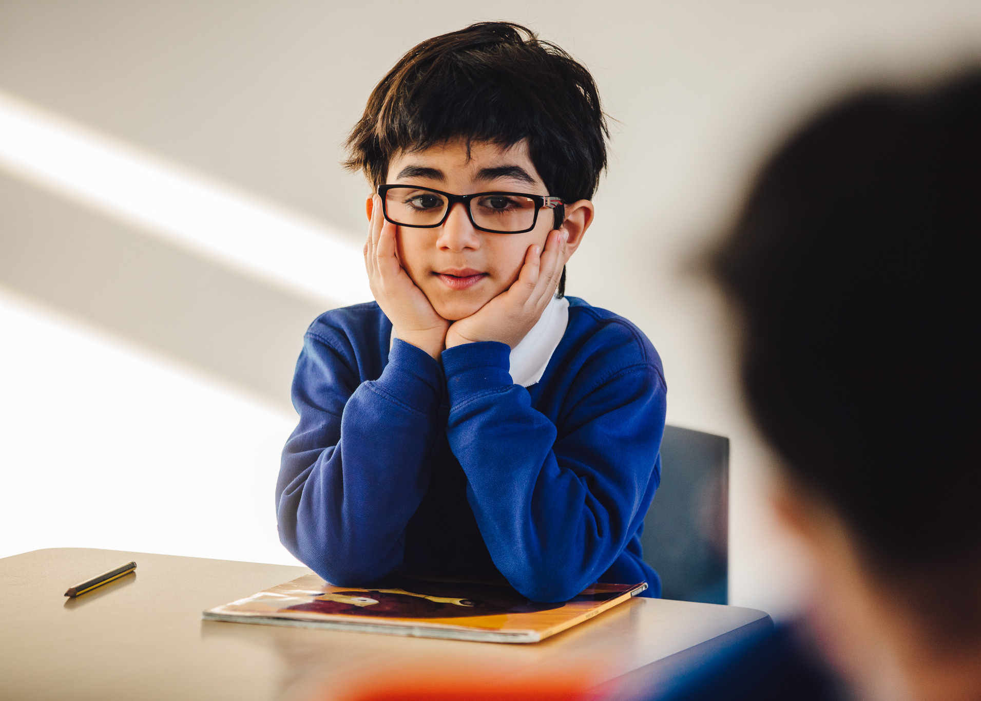 A young boy listens intently to his teacher