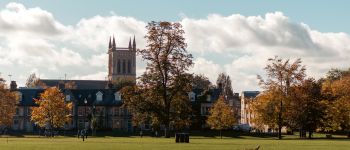 University of Cambridge building with trees and a green