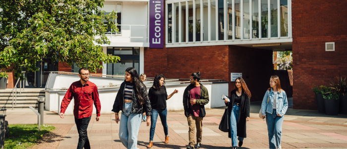 group of students walking in front of the economics building