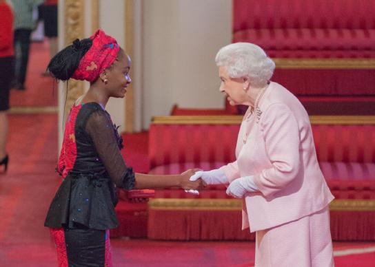 Nkechikwu Azinge accepting award from Queen