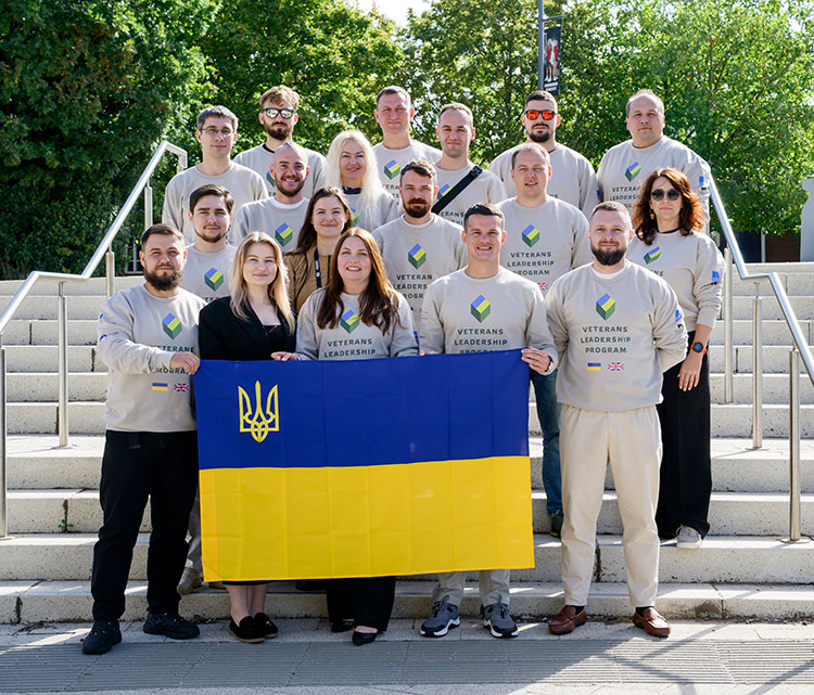 A picture of the Ukraine veterans that attended the WBS leadership programme at the University of Warwick in September 2025 holding the flag of Ukraine.