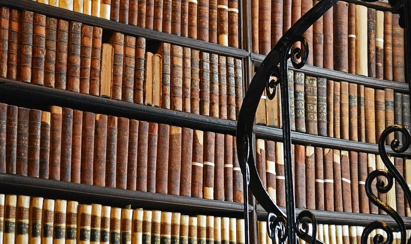 A winding black stairwell against the backdrop of a bookcase