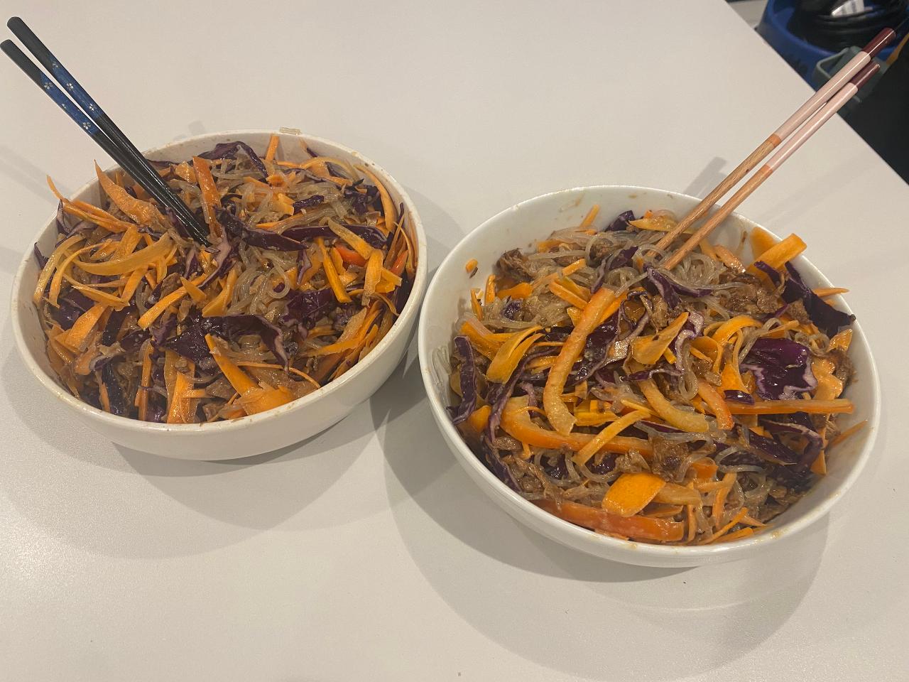 Two bowls of cold noodle salad, with chopsticks