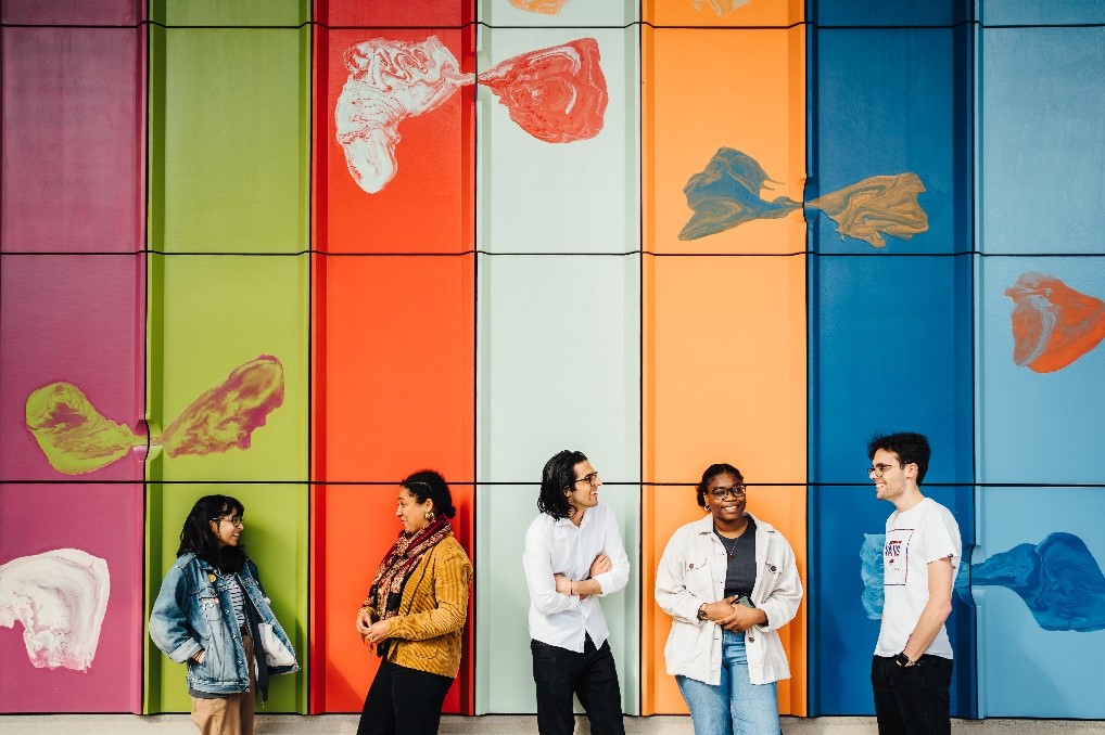 Students in front of coloured stripe backgroun