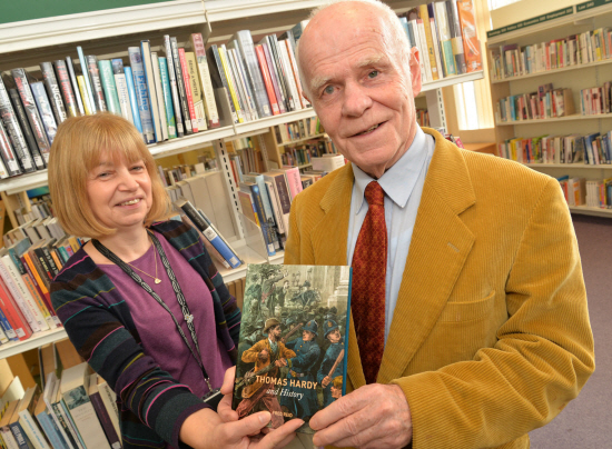 Image of Fred in 2017, following the publication of his book 'Thomas Hardy and History'. Fred is wearing a yellow jacket and red tie, and is next to a Kenilworth librarian.