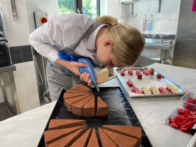 Image of Jessica using a piping bag on a chocolate cake