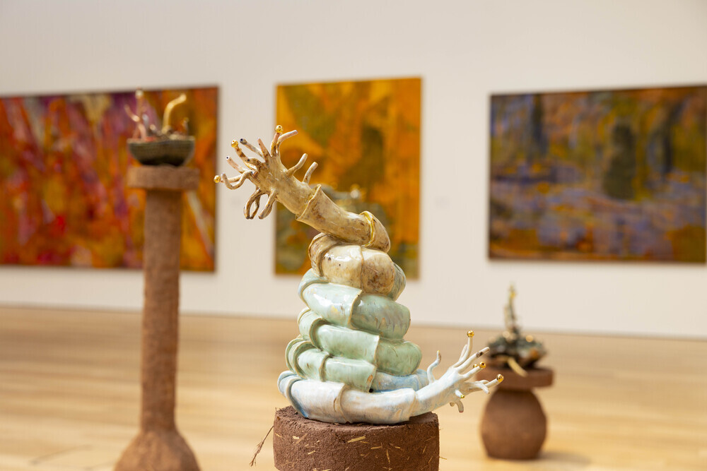 a sculpture of a coil with hands at each end