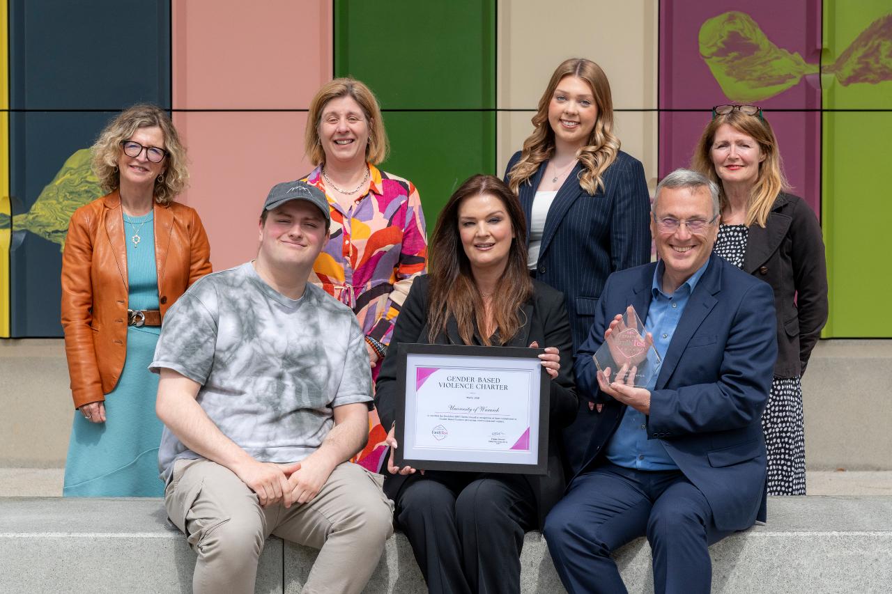 Emily Drouet (centre), presenting the Charter award to Stuart Croft (right), with other people in surrounds