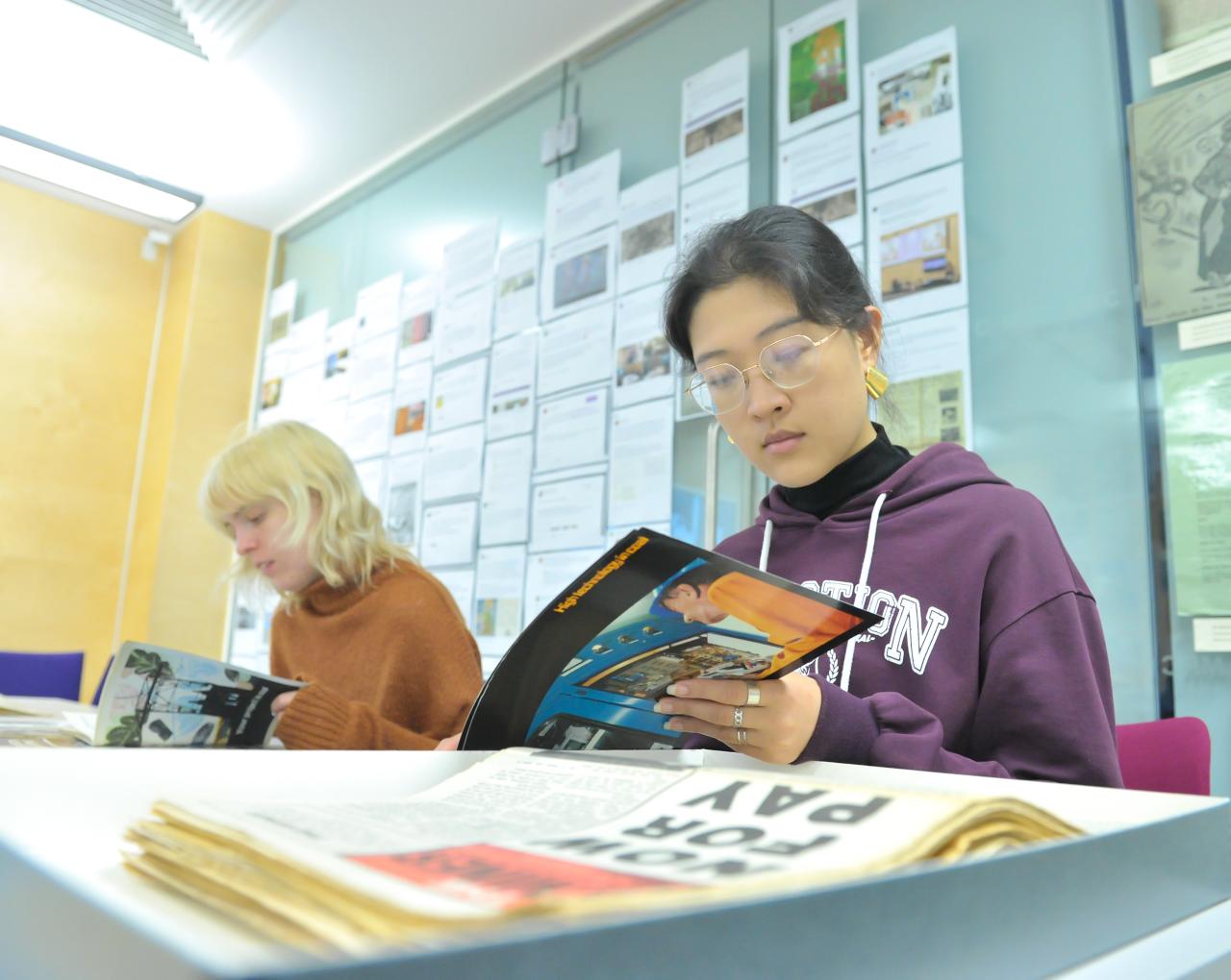 A student reading through a booklet in the Modern Records Centre