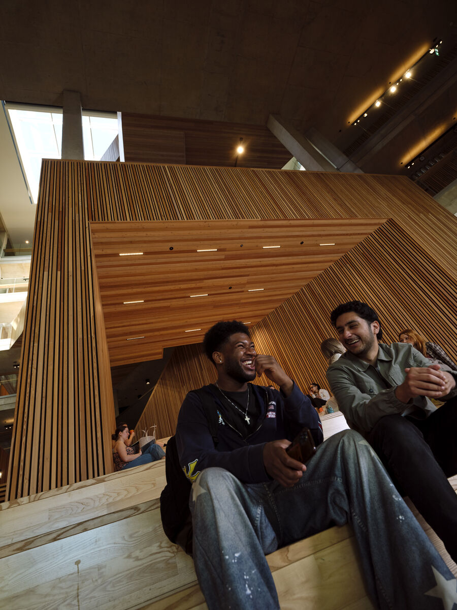 A couple of students laughing together inside the Faculty of Arts Building 
