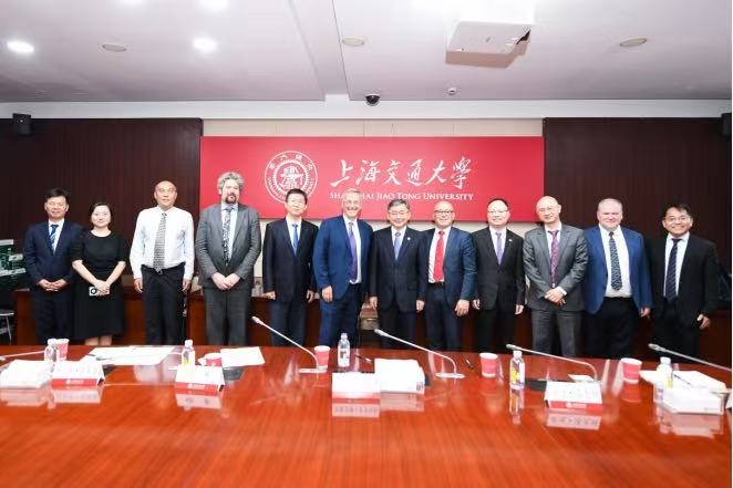Professor Stuart Croft meeting with senior representatives of SJTU university, stood behind a table. 