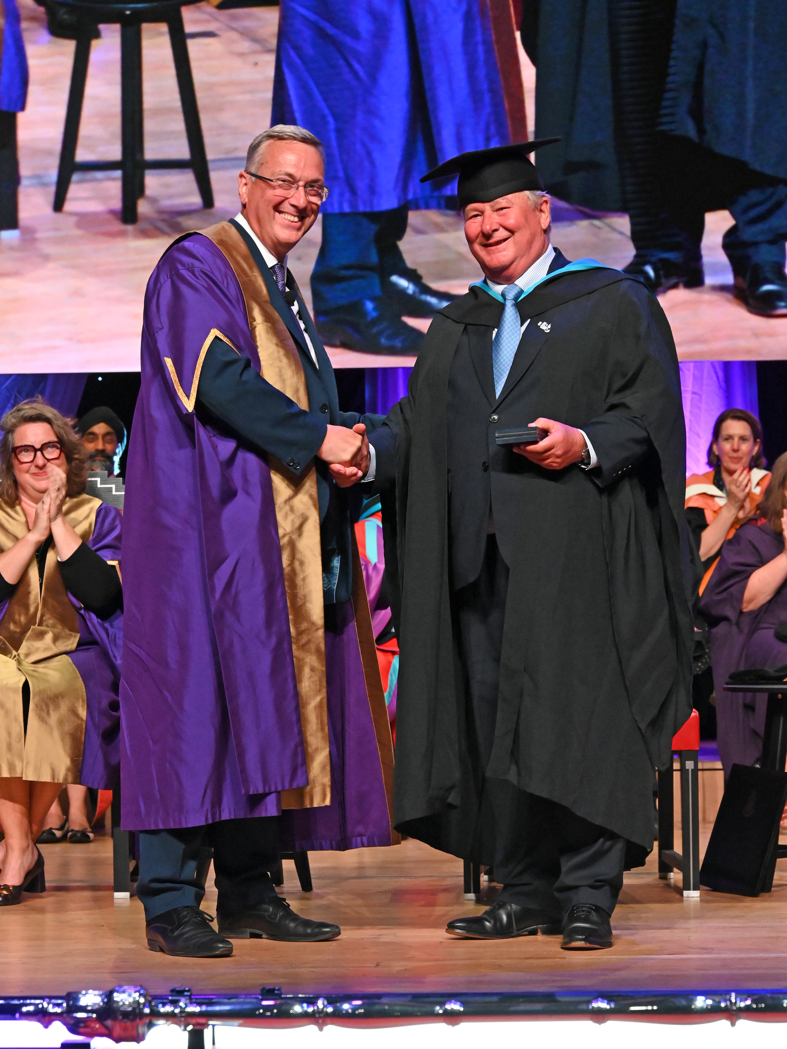Tim Hartnoll (right) receiving the Benefactors Medal from Vice-Chancellor Stuart Croft (left) at graduation ceremony in July 2025