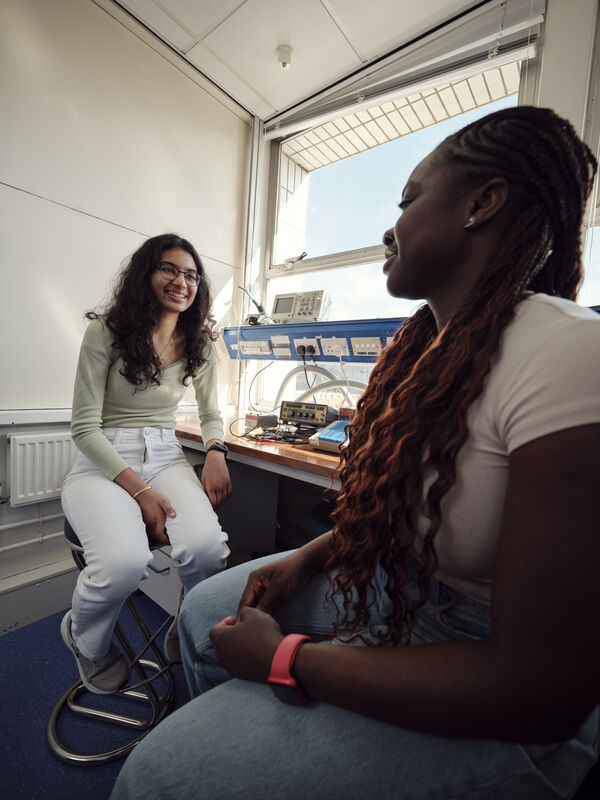 Two female students talking to each other about work
