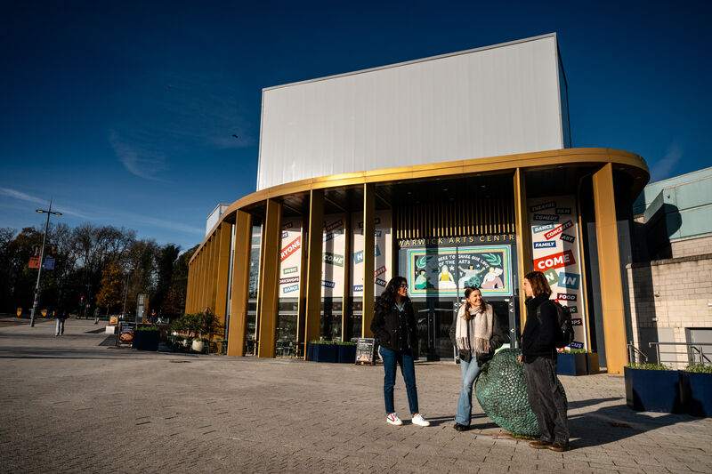 Three Warwick students in front of the Warwick Arts Centre