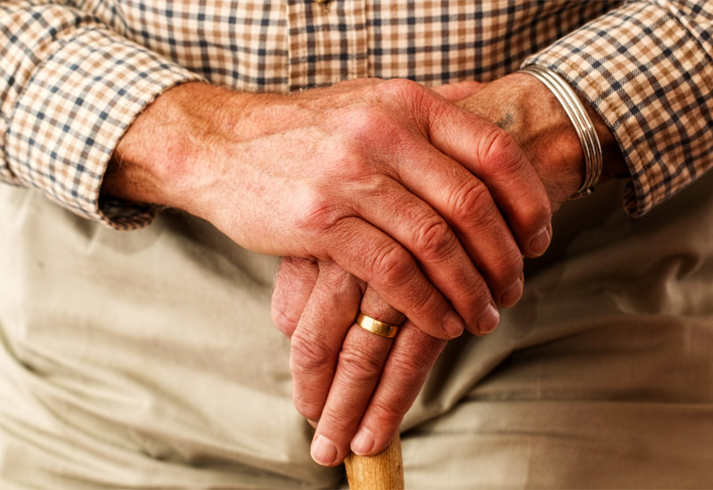 Elderly man's hands on walking stick