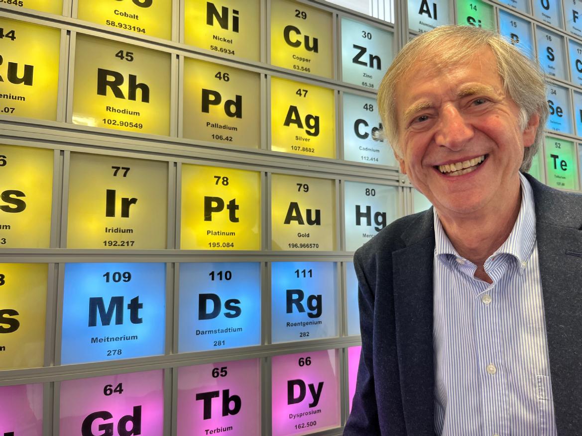 Professor Sadler of the Department of Chemistry at the University of Warwick, standing next to his home-built periodic table.