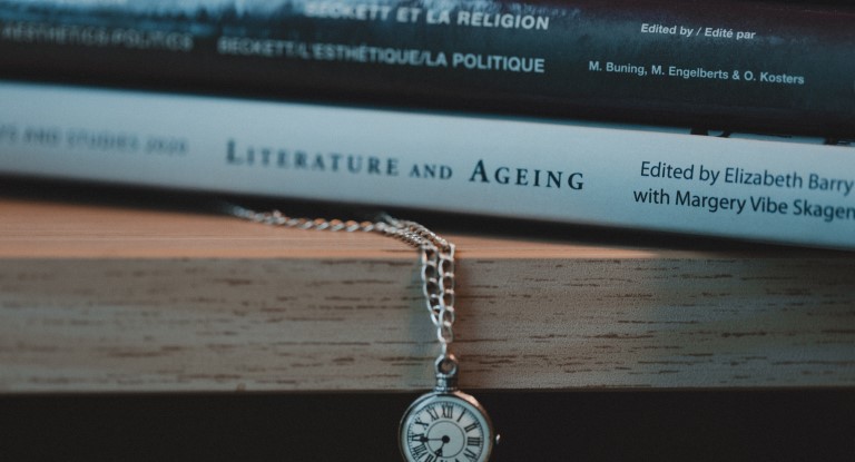 Books and a pocket watch on a shelft