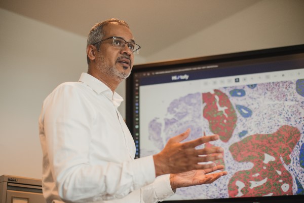 Nasir talking in front of a screen