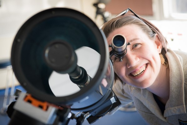 A researcher looking through a telescope