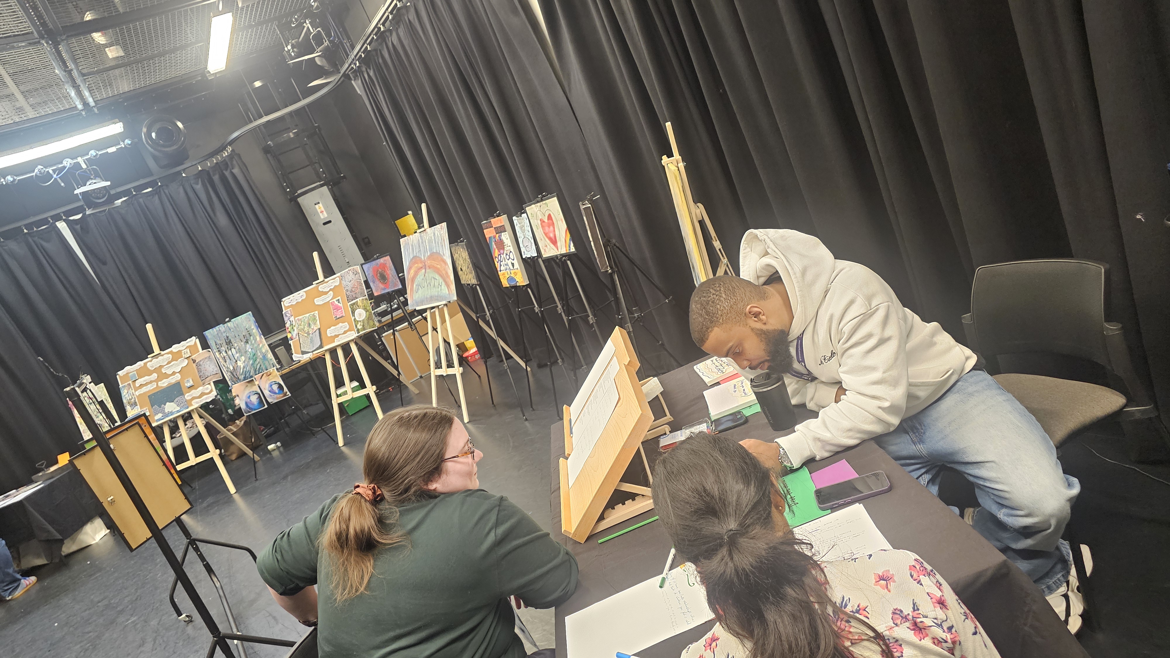 Picture of three people sat around a table discussing poetry at the Resonate festival.