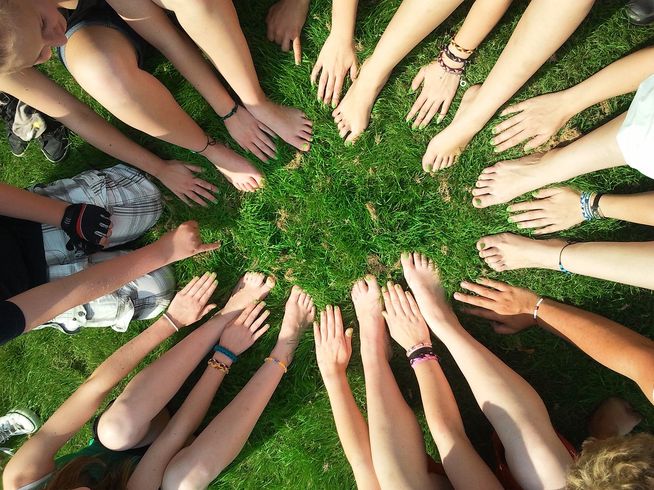 Hands and feet in a circle on grass making a circle shape 