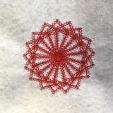 Red stitching on a white felt fabric background. The cross-stitching creates a circular shape with lots of corners around its edge..