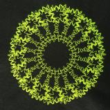 Neon yellow stitching on a black felt fabric background. The stitching creates a ring donut shup with some star-like gaps in it. 
