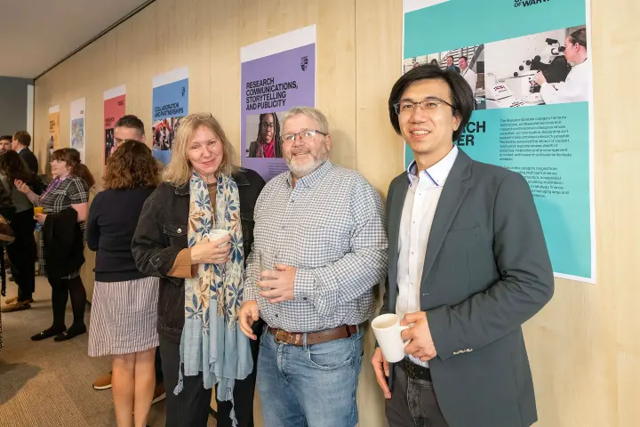 People standing in front of Research Celebration posters