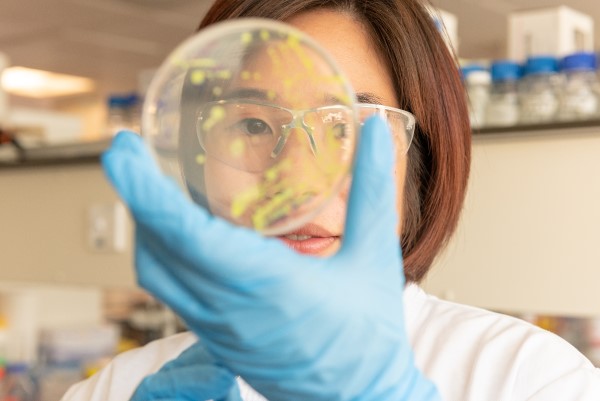 A woman holding a petri dish