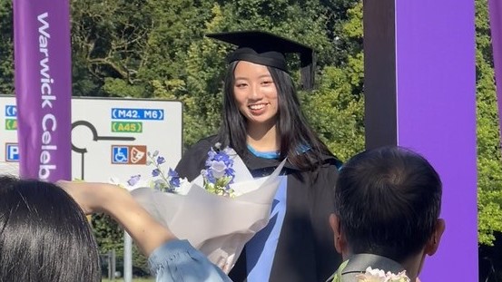 Proud student wearing a graduation gown outdoors